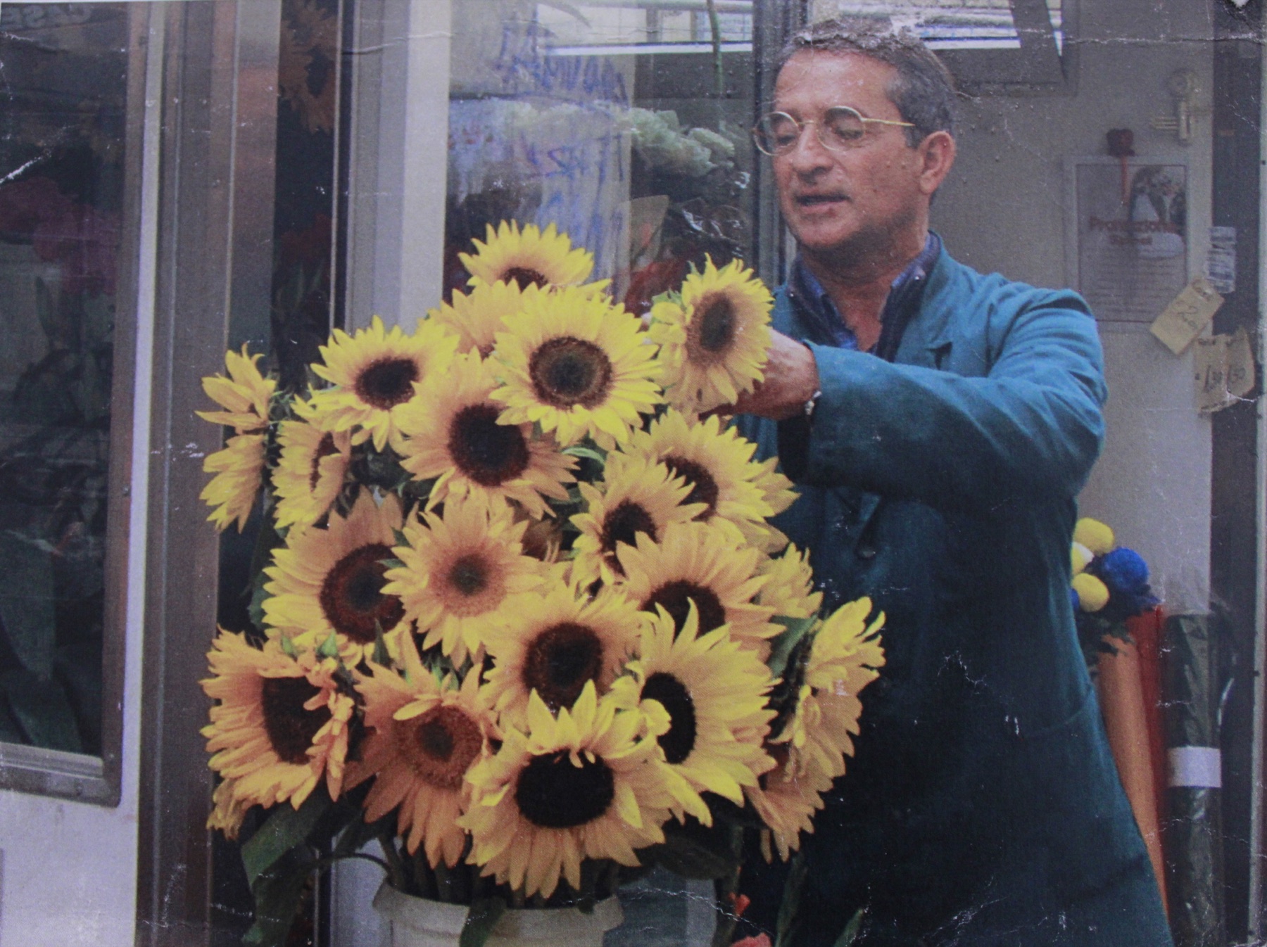 Fiorista al lavoro tra fiori freschi e composizioni